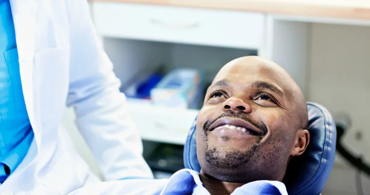 A man in a dentist's chair smiling
