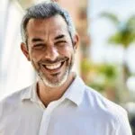 A man in a white shirt smiling