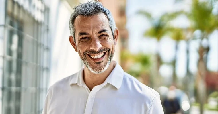 A man in a white shirt smiling
