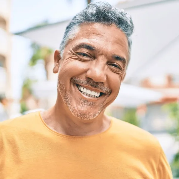 A man smiles after his cosmetic dental treatment.